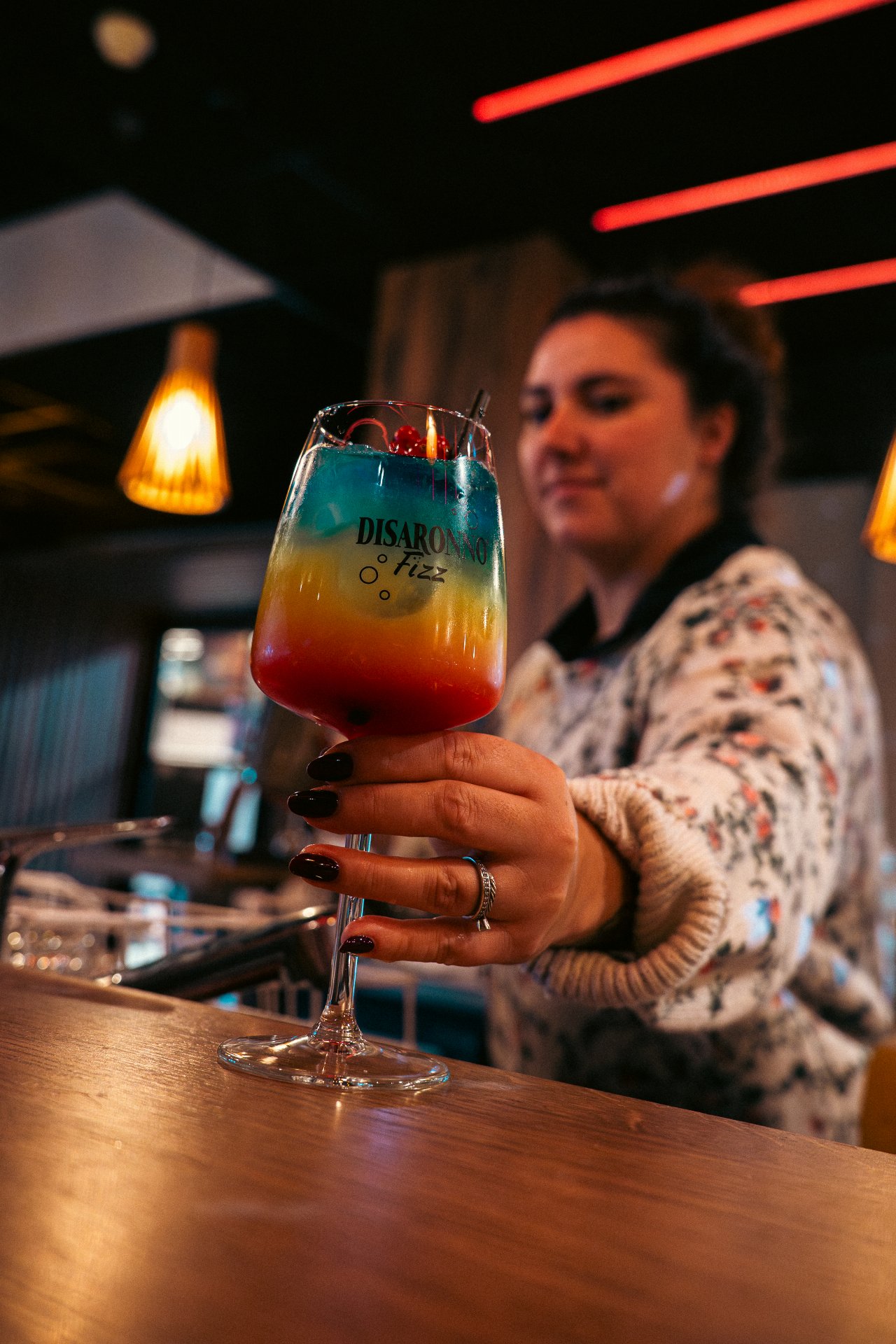 Barman mixologue en train de préparer un cocktail derrière le comptoir du WOODS.