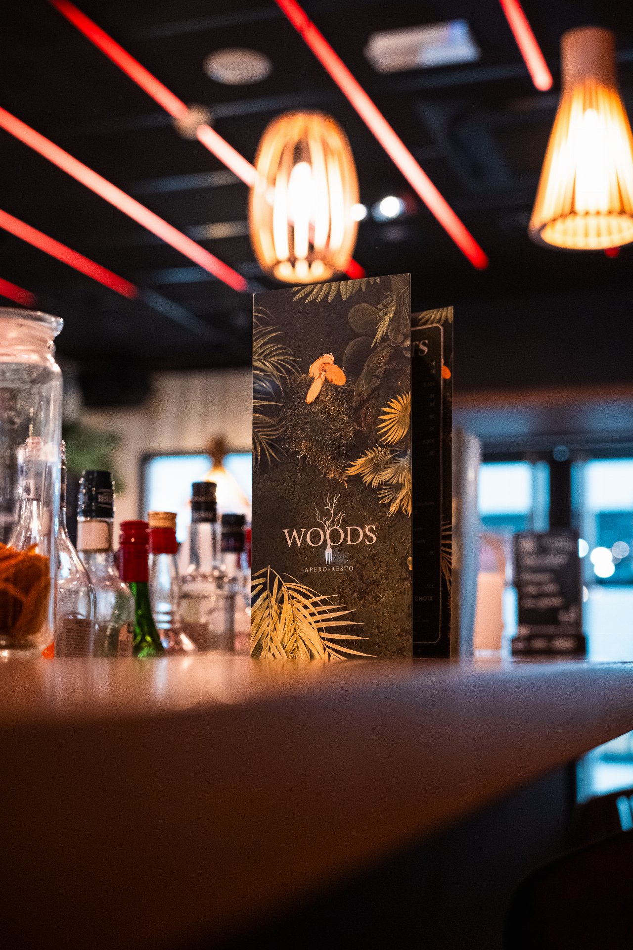 La carte du Woods sur le bar, ambiance chaleureuse et lumière d'ambiance.